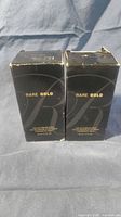 Front view of two sealed Avon Rare Gold cartons