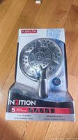 Front of sealed retail box showing Delta In2ition brushed nickel 2-in-1 showerhead