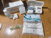 All components laid out including device, solution, straps, cords, manuals, box