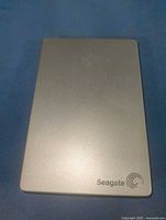Front view of silver Seagate portable drive showing logo and casing condition