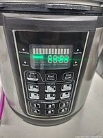 Front digital display and control panel showing interface and programmed buttons.