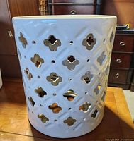 Front and side view showing the white ceramic structure with lattice cutout quatrefoil design.