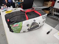 Camping tent storage bag with label showing model and features, placed on a table.