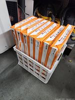 7 packs of Universal brand copy paper stacked in a white crate, orange and white packaging visible