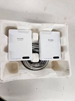 Two D-Link Powerline AV2 2000 adapters in white with an Ethernet cable inside molded packaging.