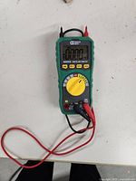 Front view of digital multimeter with attached red and black test leads, rotary dial set to off, LCD screen showing zeroes