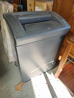 Large black GBC shredmaster 5260X paper shredder shown standing on the floor near furniture and boxes.