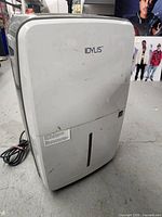 Front and side view of the Idylis dehumidifier showing brand logo, front vent, and overall condition with scratches on back.