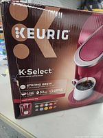 Front and side of Keurig K-Select coffee maker box showing branding and coffee brewing image.