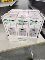 Display of 12 white boxed MaxLite Energy Saving Power Strips in a retail display box on table