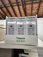 Front view of three MaxLite Energy Saving Power Strip boxes showing product image and branding.
