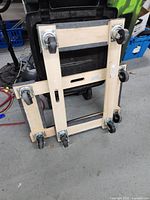 Two wooden dollies stacked, showing the caster wheels and handles.