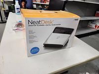 Box of NeatDesk Desktop Scanner Digital Filing System showing front and product features
