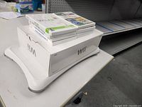 Photo of Wii Fit balance board with stacked games and original box