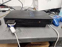 Full view of PlayStation 2 console with controllers and memory card connected on table