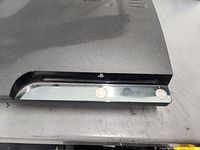 Black PlayStation 3 console front with power and eject buttons visible.