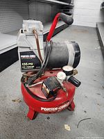 Side view of Porter-Cable Jetstream air compressor showing the red tank, control gauges, red handle, and motor unit.