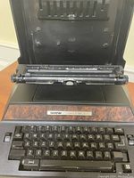 Front and top view of the Brother Correct-O-Ball XL-1 typewriter showing keyboard and paper holder.
