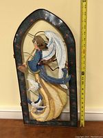 Front view of the metal Christmas angel wall hanging with measuring tape showing approximately 22 inches in height.