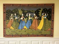 Front view of large wall hanging depicting seven traditionally dressed women in colorful dresses against a landscape background.