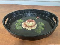 Top and angled view of larger oval tray with floral design and handles
