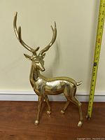 Brass standing deer figurine approximately 9 inches tall.
