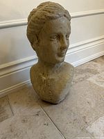 Front view of one female bust sculpture showing facial details and textured surface.