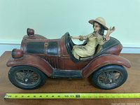 Photo showing side profile of the vintage toy car with woman figurine; highlights the car design and figurine details