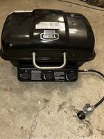 Top view of the Expert Grill portable gas BBQ grill showing black lid with silver handle and brand label.