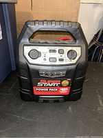Front view of Super Start AGM Power Pack jump starter showing control panel, output socket, and branding.