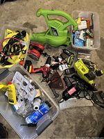 Overall view of various tools and hardware accessories including leaf blower, drill, sander, screws, and hardware