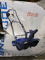 Outer box of Snow Joe snow thrower with product image and highlighted 2x LED lights feature