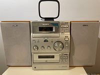 Front view of Sony Micro Hi-Fi system with radio tuner, cassette deck, CD player, and two speakers.
