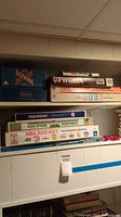 Six board games on a shelf including Upwords and The Game of Life