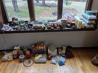 Wide view of all candles, holders, potpourri bags, decorative birds and stones arranged on windowsill and floor in front of window