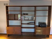 Full view of three-section modular shelving system mounted side by side against wall