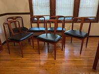 Six chairs arranged in front of a window showing overall set