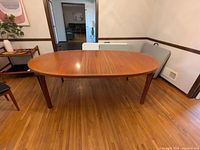 Front view of oval table with one leaf installed, showing overall shape and finish