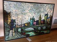 Framed original painting on canvas showing cityscape with river, bridge, buildings and boats.