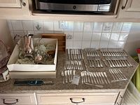 Photo showing unmarked plated coffee set including coffee pot, creamer, sugar bowl, plus plates and multiple utensils laid out on countertop.