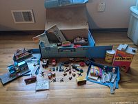 Entire lot arrayed on a wood floor showing box, buildings, cars, and accessories.