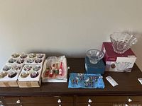 Full lot view showing crystal bowls on right and boxed beverage bottle ornaments on left with butterfly ornaments in front