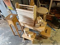 Photo showing a variety of wooden furniture and craft items including stools, racks, boxes and blocks, mostly unfinished.