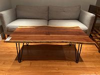 Front view of the table showing the live edge wood top and hairpin legs