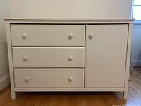 Front view of entire dresser showing three drawers on left and cabinet door on right