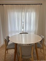 Full view of both curtain panels hung on rod behind dining table.