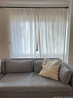Two linen panels hung on black wrought iron rod above sofa, full view