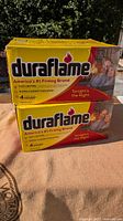 Two stacked packs of Duraflame firelogs showing front packaging with brand and product details