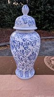 Full view of the assembled tall blue and white ginger jar with lid on.