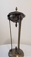 Front view of the lacquered brass incense burner showing tripod legs with lion heads and finial on lid